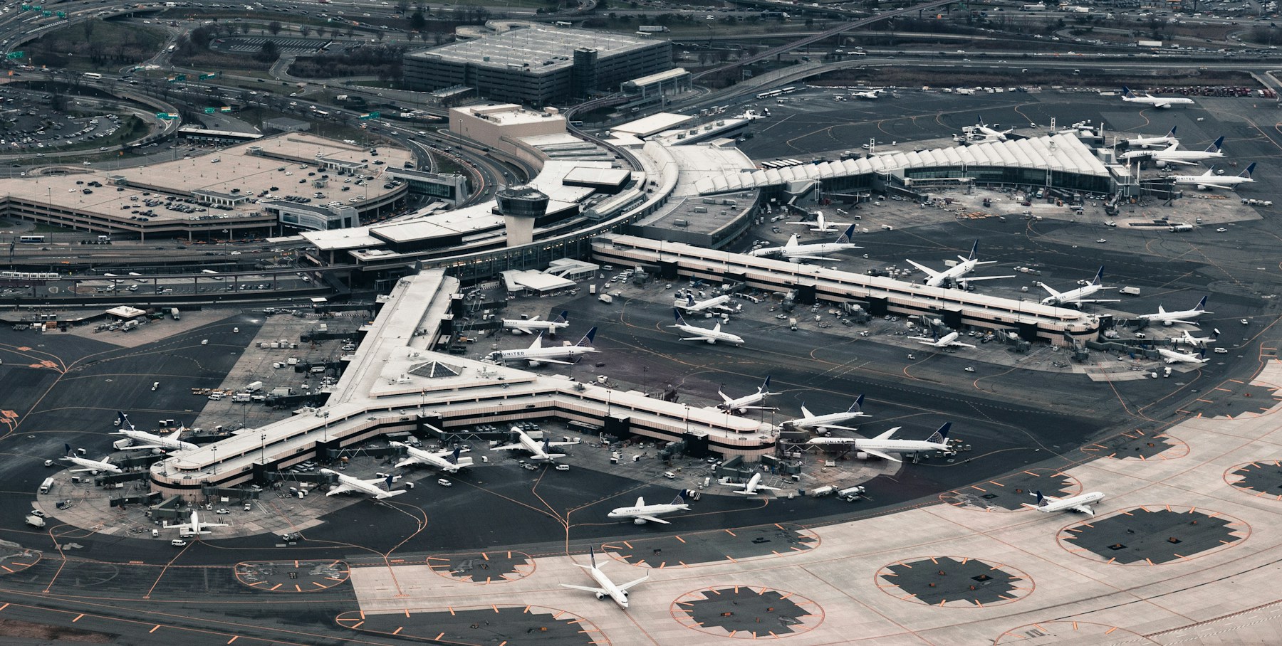 Aerial view of an airport terminal, runways, gates, and aircraft